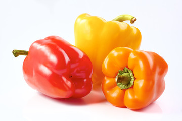 Three bell peppers, red, yellow and orange, isolated on white background