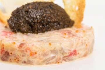Salmon tartare with black truffle sauce.