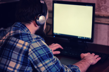 male behind computer with headphones
