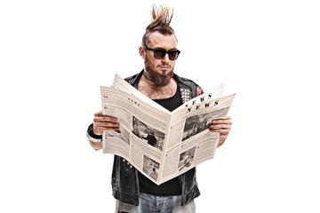 Male punk rocker reading a newspaper