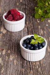 Blueberries and raspberries bowl on wooden table