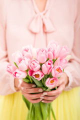 Bunch of tulips in woman's hands, shallow dof.