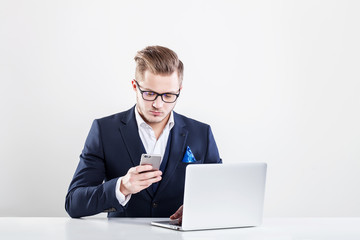 Young businessman working in office, sitting at desk, looking at