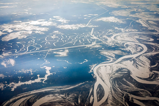 Airplane panoramic view of a river in Far East of Russia with winter snow