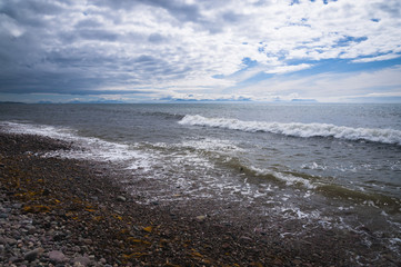 Looking at the Isle of Skye from Melvaig shore on a cloudy day across The Minch