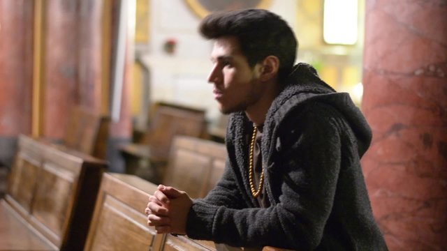 Young man praying in church