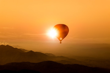 Silhouette of hot air balloon over mountain
