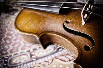 Still life with vintage violin. Closeup of old wooden violin. Stringed music instrument on abstract background