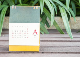 Closeup cute calendar in april on blurred garden view background