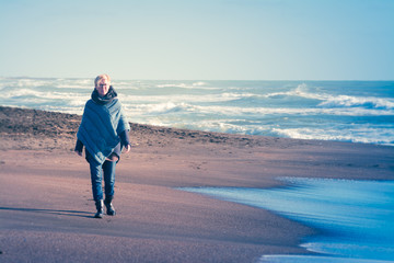 Woman that walks on the seashore in winter