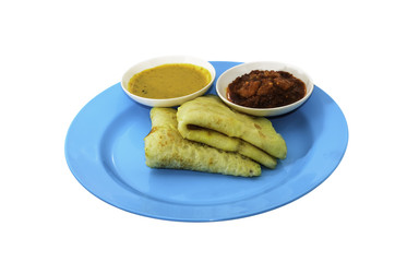 Two slices of homemade plain pancake with curry and shrimp gravy or sambal udang on cyan plate on white background
