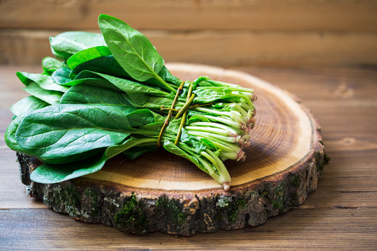 Spinach leaves on wooden circle