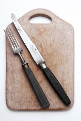 Holzschneidebrett mit Messer und Gabel, freigestellt