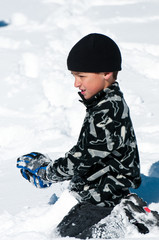 Fototapeta na wymiar Cute boy playing in the snow.