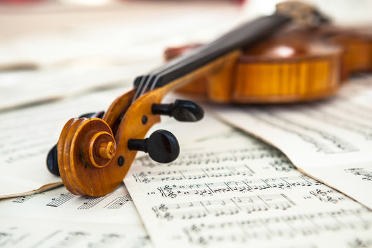 Old violin lying on the sheet of music