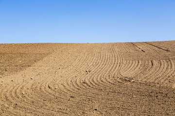 landscape with plowed field and blue sky