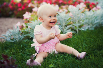 Smiling portrait cute baby-girl on green grass