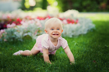 Smiling portrait cute baby-girl on green grass