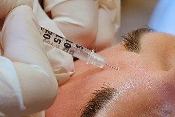 Close-up forehead anti-wrinkle treatment with syringe