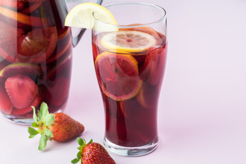 Fototapeta na wymiar Pitcher and glass with sangria and strawberries.