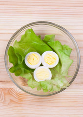 Cut quail eggs and lettuce in a bowl