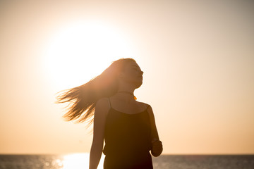 sunset and silhouette of a teenage girl in motion