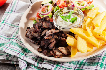 Grilled meat with French fries and fresh vegetables