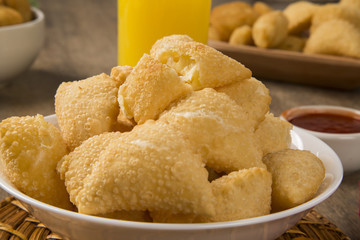 Pastel, a Brazilian snack, with a bar in the background. Cheese