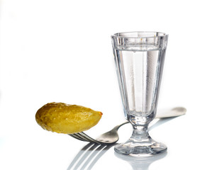 Glass of Russian vodka with pickled cucumber on a white background