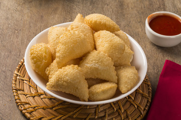 Pastel, a Brazilian snack, with a bar in the background. Cheese