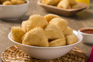Pastel, a Brazilian snack, with a bar in the background. Cheese