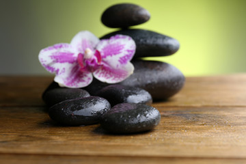 Black pebbles with orchid on wooden table