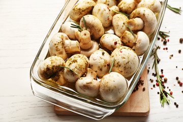 Marinating mushrooms with spices on wooden table