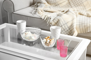 Low table with sweets and two cups in living room