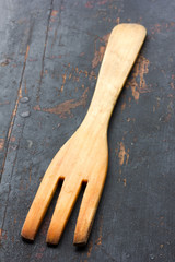 wooden kitchen fork, on the old black table closeup selective focus. rustic style