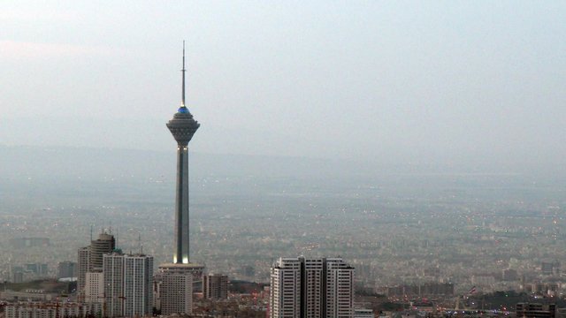 An airplane landing just behind Milad Tower also known as Tehran tower, the new symbol of tehran