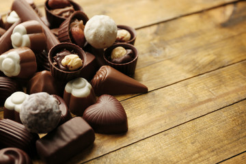 Delicious chocolate candies on wooden background