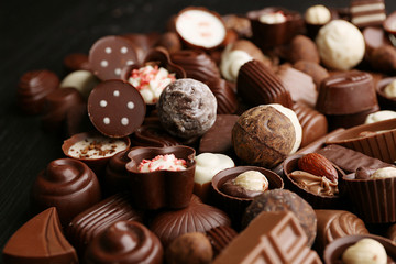 Delicious chocolate candies on wooden background, close up