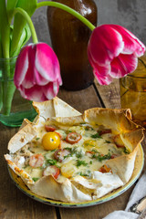 pizza on pita bread with tomatoes, cheese, and tulips