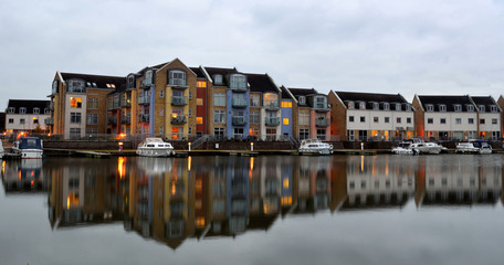 Fototapeta na wymiar Marina apartments Eynesbury St Neots. New marina built on the River ouse. Photo taken early evening with lights and reflection.