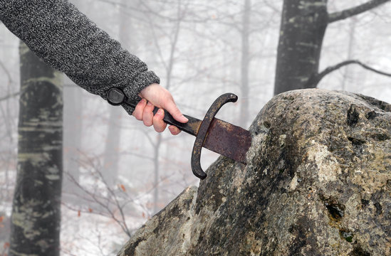 knight tries to remove Excalibur sword in the stone
