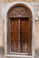 Fototapeta na wymiar traditional wooden ornate door in stone town, zanzibar, tanzania