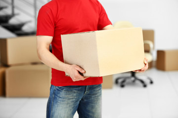 Man holding carton box in the room, close up