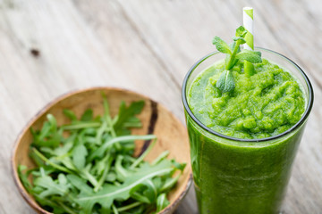 Rucola smoothie, on the grey  background.