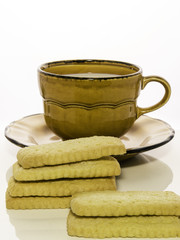 Una colazione semplice: tazza di latte con biscotti e sfondo bianco