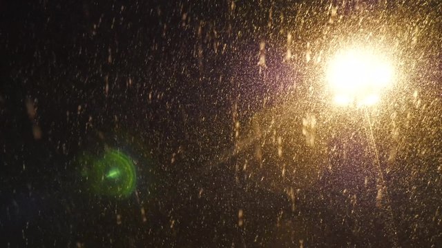 Heavy snowing at night with outdoor lamps