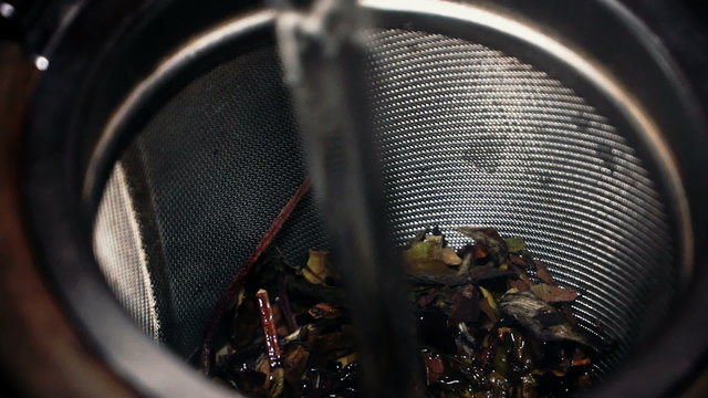 Tea strainer with Chinese white tea. Tea is poured boiling water.