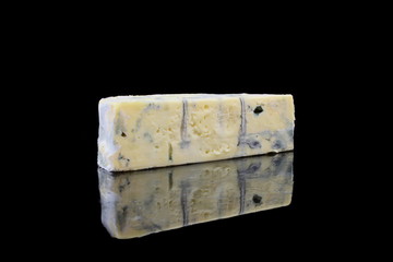 ein stück blauschimmelkäse auf schwarzen hintergrund