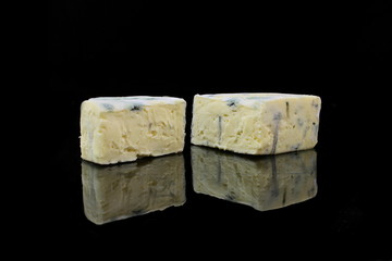zwei stücke blauschimmelkäse auf schwarzen hintergrund