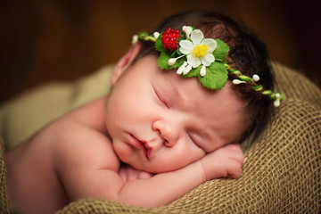 Newborn baby girl has sweet dreams in strawberries © Yarkovoy